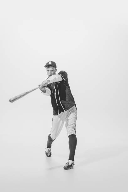 retrato de joven, jugador de béisbol, bateador listo para golpear pelota con bate. fotografía en blanco y negro - men baseball baseball cap baseball bat fotografías e imágenes de stock