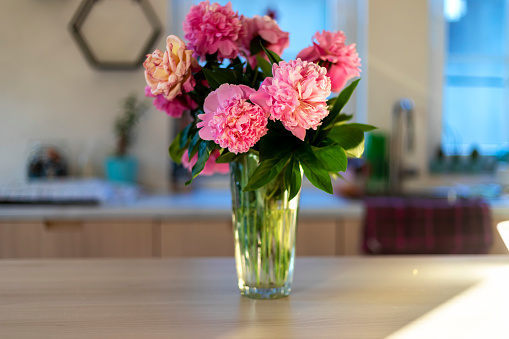 Close up of vase of flowers on kitchen table.
