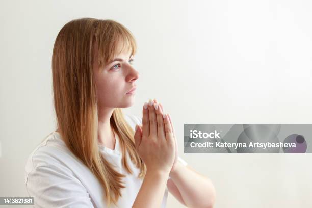 Young Woman Prays Says A Prayer On A White Background Stock Photo - Download Image Now