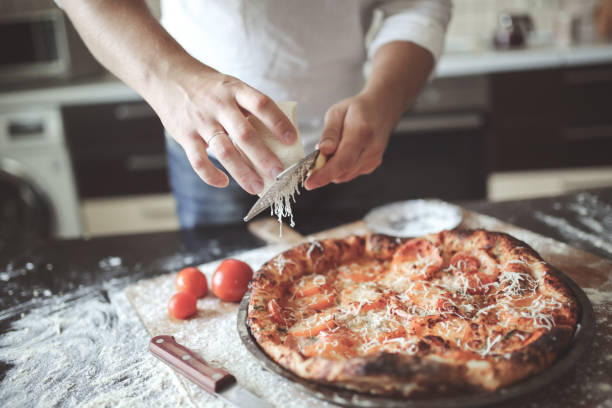 istock male hands rubbed cheese grated on pizza in home 1413822002