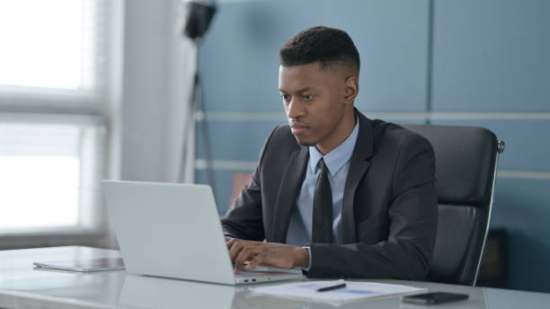 istock African Businessman Working on Laptop in Office 1413824481