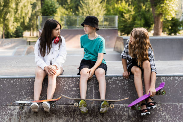 スケートボードとペニーボードでポーズをとっている子供たちの友人は、スケートボードパークのスポーツランプでポーズをとっています。極端なライフスタイル。一緒に楽しんでいるアク� - skateboard park ramp park skateboard ストックフォトと画像