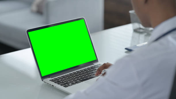 istock Rear View of African Doctor using Laptop with Open Screen 1413825388