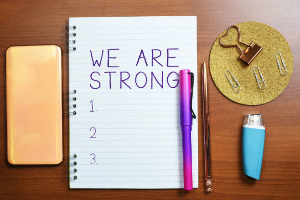 istock Handwriting text We Are Strong. Word Written on Have great strength healthy powerful achieving everything Notebook With Important Message On Desk With Office Supplies. 1413825448