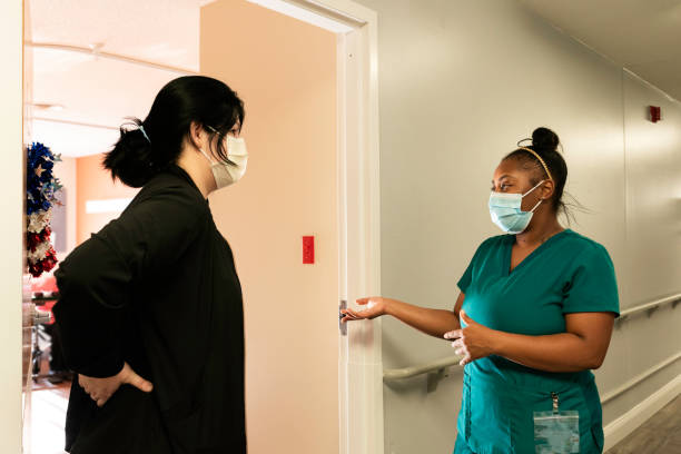 istock Two CNAs talking in a hallway at work, Midwest, Indiana, USA 1413826332