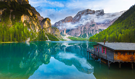 Boat hut on Braies Lake with Seekofel mount on background. Colorful autumn sunrise of Italian Alps, Naturpark Fanes-Sennes-Prags, Dolomite, Italy, Europe. Traveling concept background.