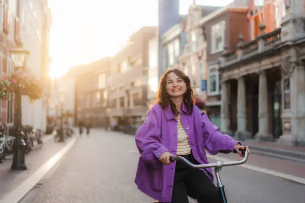 Photo of Woman riding bicycle in the city at sunset