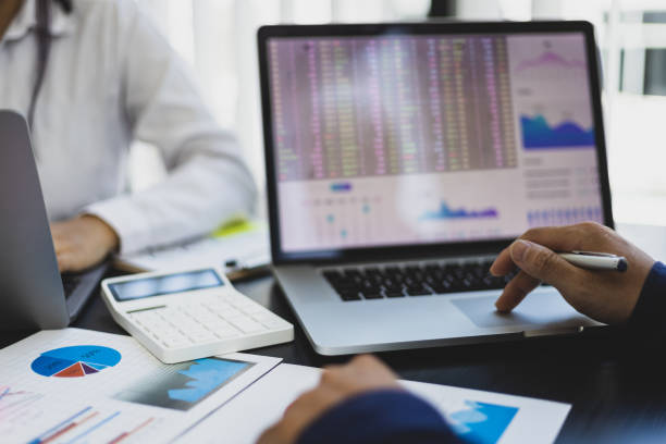 istock Accountants in the office working with laptops and calculators analyzing financial and auditing documents. 1413828372