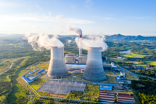 Nuclear power plant. Cooling towers on the background of blue sky and mountains.