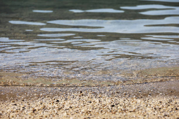 istock Selective focus to small pebble stones on a beach with rolling wave 1413829475