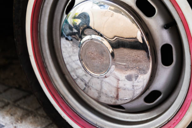Vintage car wheel with chromed cap and red stripe, close up