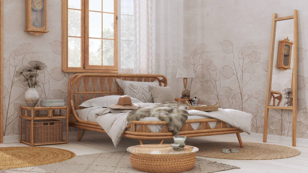 Wooden farmhouse bedroom in boho chic style. Rattan bed and furniture in white and beige tones. Country wallpaper, vintage interior design stock photo