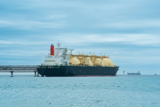 liquefied natural gas carrier tanker during loading at an lng offshore terminal, in the distance the oil export terminal is visible in the sea - naval ship imagens e fotografias de stock