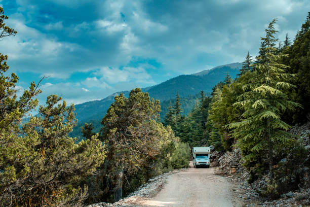 istock Wooded mountain terrain,Caravan on dirt road 1413836166