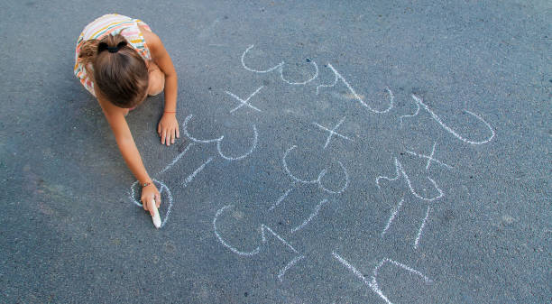 istock Girl Doing Mathematics With Chalk On Sidewalk 1413838975