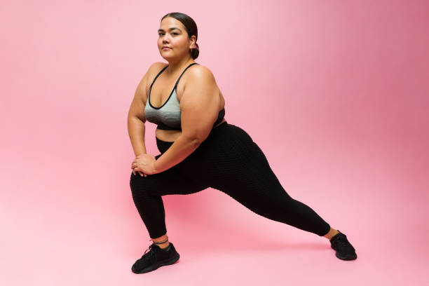 istock Obese young woman stretching her legs before exercising 1413839243