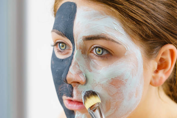 istock Girl black mask on half face apply white mud 1413839539