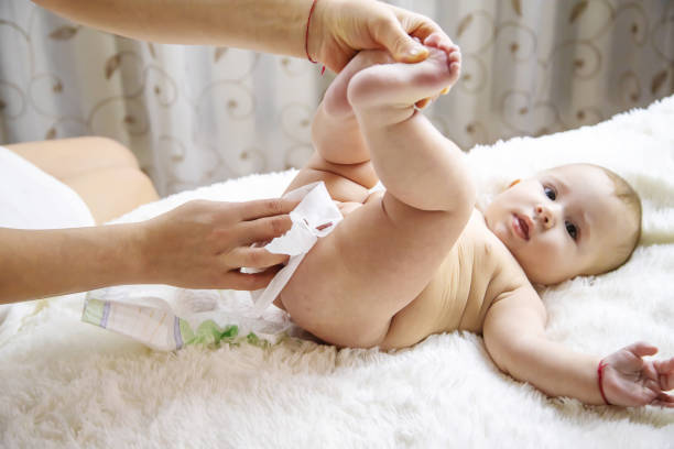 istock Mother Cleaning Baby Lying On Bed At Home 1413839955