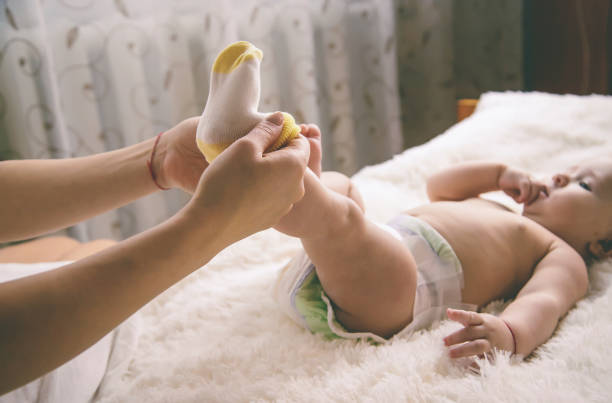 istock Mother With Baby Lying On Bed At Home 1413840001