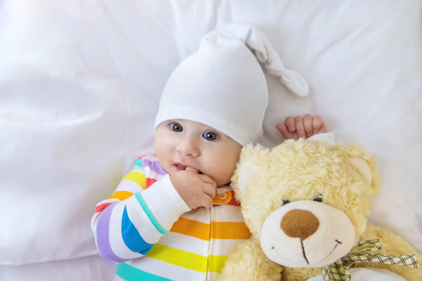 portrait of cute baby girl with teddy bear - thumb sucking cute small lying down imagens e fotografias de stock