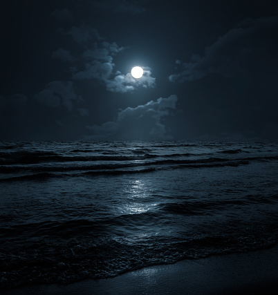 Moon over blue sea or ocean. Night view. A good background for the theme of travel, vacation, voyage.