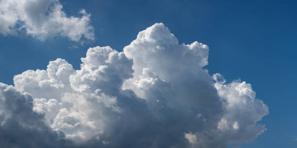 beautiful cumulus clouds against the blue sky.. panoramic shot of a cloud cluster. wide format. - weatherd imagens e fotografias de stock
