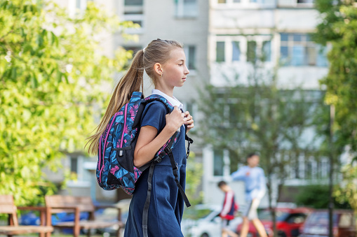 Beautiful teen girl with backpack goes to school. Concept of back to school, education and childhood