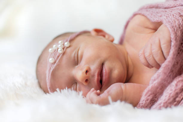 istock Close-Up Of Cute Baby Sleeping On Bed 1413841094