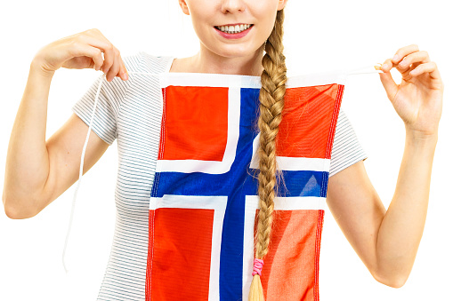 Blonde young woman teen girl braid hair holds norwegian flag. Scandinavian people.