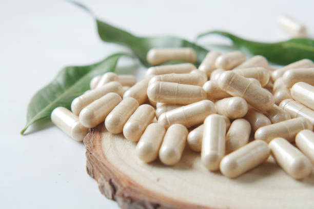 istock top view of herbal medicine capsule dropping on white 1413845436