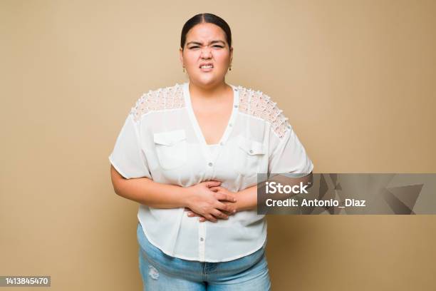 Ill Fat Woman Suffering Pain From A Stomachache Or Indigestion Stock Photo - Download Image Now