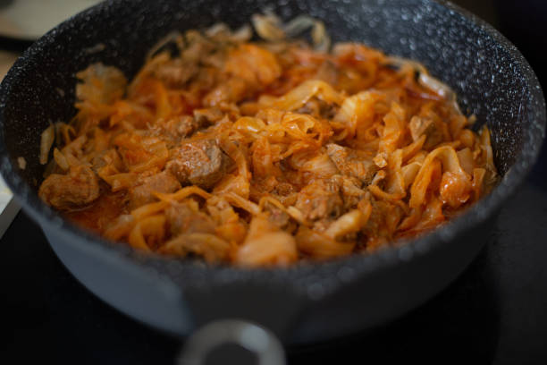 istock Stewed cabbage in a frying pan. Cooking recipe. 1413845496