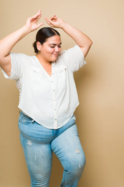 istock Young obese woman having fun and enjoying a fun dance 1413845614