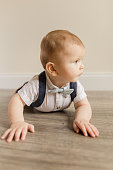 istock 7-Month-Old Baby Boy Dressed Like a Little Gentleman With a Bowtie Laying on a Wooden Floor 1413848976