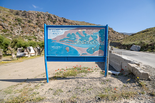 Welcome Sign at Dionyssos Beach in Rethymno Regional Unit on Crete, Greece, with a map illustration visible.