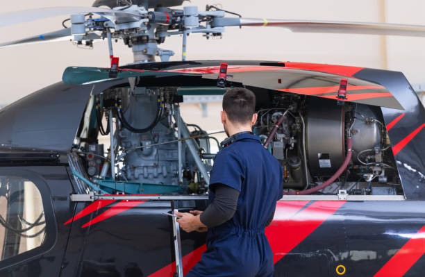 istock Aero Mechanic Fixing And Checking A Helicopter In Hangar 1413851189