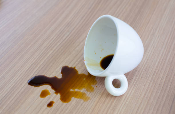 istock Spilled coffee cup stain on wooden floor 1413854453