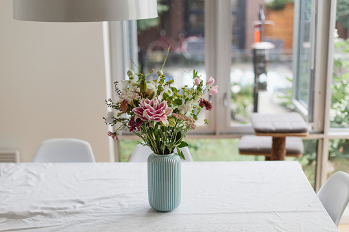 wild flowers in vase on white windowsill