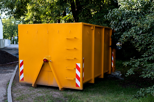 Yellow metal construction trash dumpsters container, house renovation.