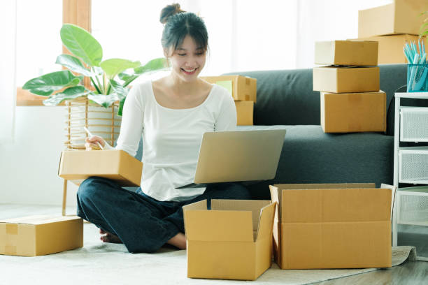 istock Online small business owner writing address on parcel box. 1413856569