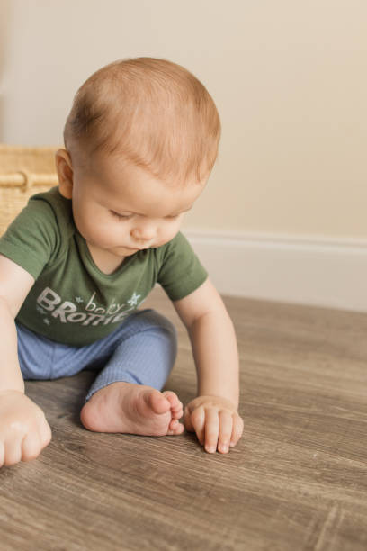istock 7-Month-Old Baby Boy With Polydactylism Learning a New Developmental Skill of Sitting Up on His Own on a Wooden Floor at Home 1413860111