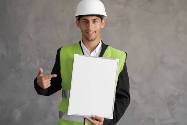 istock Arabic Man engineer wearing a hard hat pointing at an clipboard 1413860299