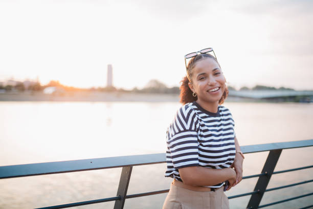 istock Happy young woman relaxing next to the river 1413861227