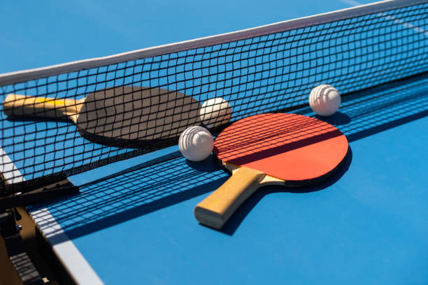 istock Table tennis rackets and a white plastic ball on a blue background. 1413861303