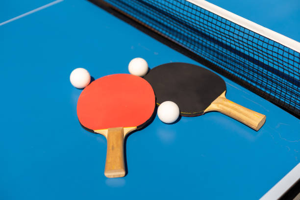 istock Table tennis rackets and a white plastic ball on a blue background. 1413861339