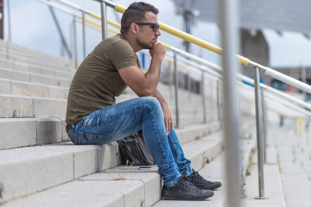 istock A young man lost in depression sitting outdoors 1413861366