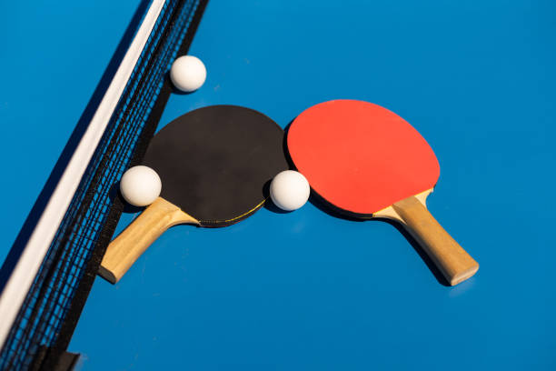 istock Table tennis rackets and a white plastic ball on a blue background. 1413861437