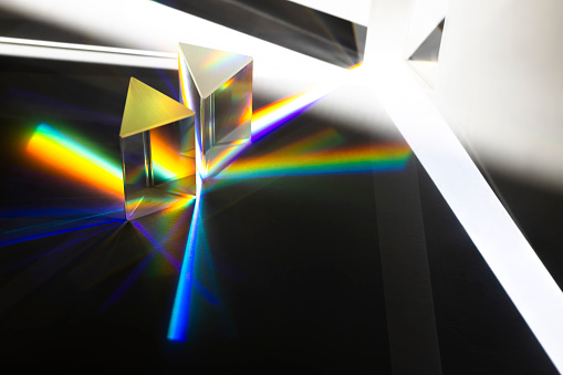 Many Triangular Prism dispersing sun beam splitting into a spectrum on white background