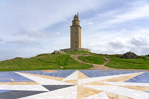 A Coruña, Spain - April 08, 2022: The rose of the winds (Rosa de los Vientos) and Hercules tower roman lighthouse in the city of A coruña in a sunny day, Galicia, Spain.