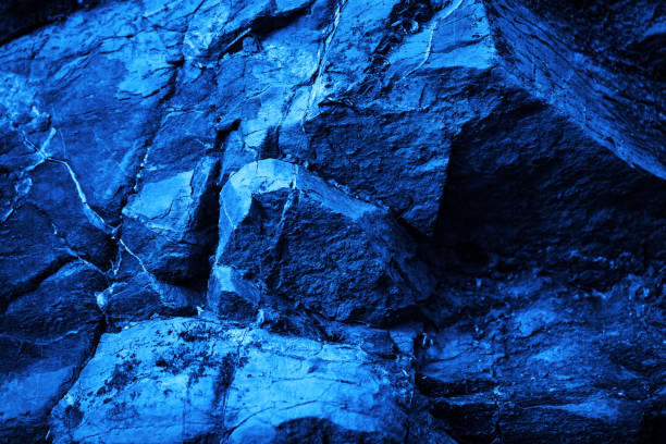istock Rock texture. Navy blue color. Toned rough mountain surface with cracks. Close-up. Stone granite background for design. 1413865122